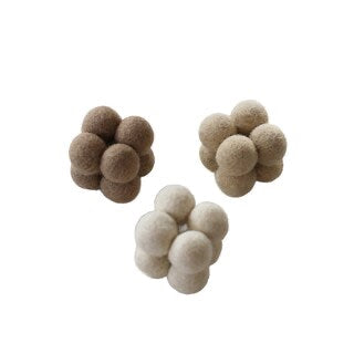 Tre strukturerade kattleksaker i ull formade som små moln i bruna och beige jordtoner