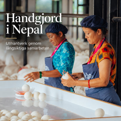 Två kvinnliga hantverkare i Nepal som formar runda bollar av vit, naturlig ull för hand till kattbäddar och ullprodukter.