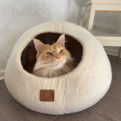 Maine Coon-katt som vilar i en vit Haven Extra stor kattgrotta i 100 % ull.