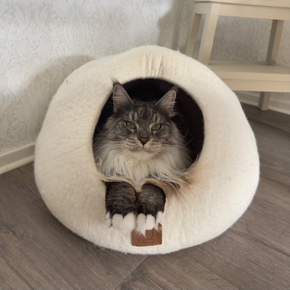 Maine Coon-katt som vilar i en vit handgjord kattgrotta i naturlig ull, Haven Extra stor.