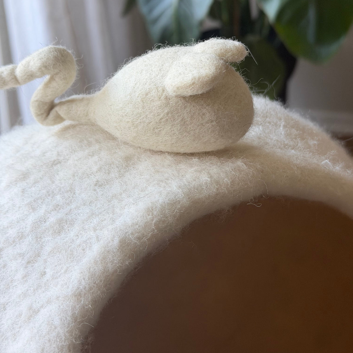 Närbild på en handgjord ullmus som dekoration på den snövita kattgrottan